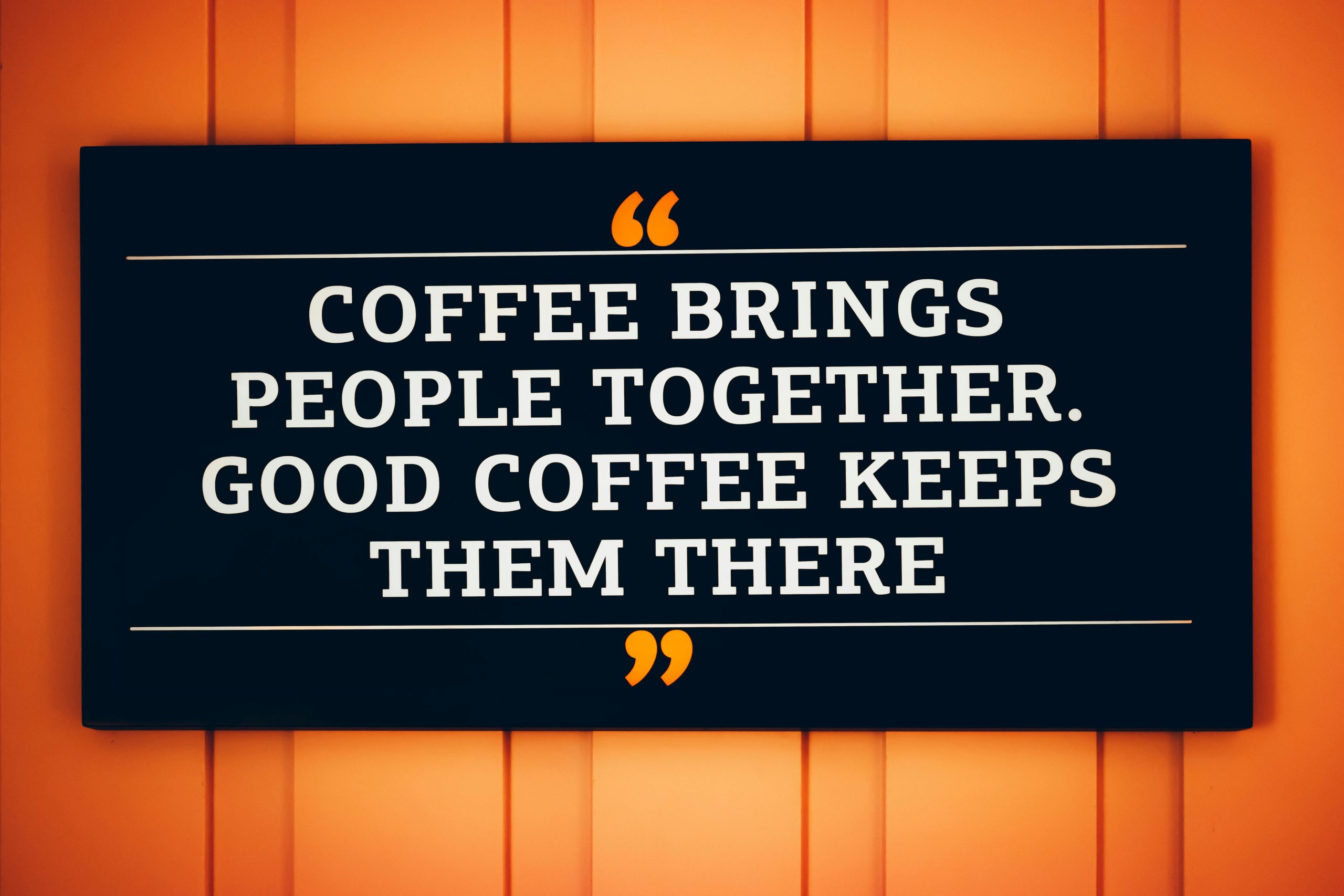 A motivational coffee quote displayed on a decorative sign.